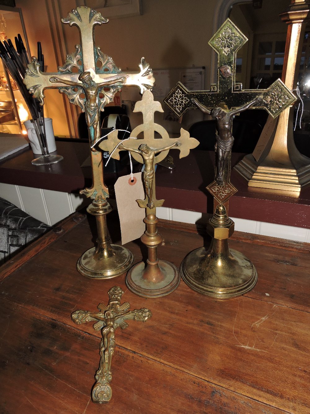 A late 19th/early 20th Century cast brass processional crucifix, later mounted on a circular plinth,