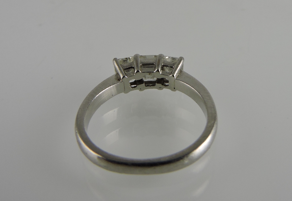 An emerald cut three-stone diamond ring, claw set in a platinum band, weight, 1.23ct. - Image 2 of 3