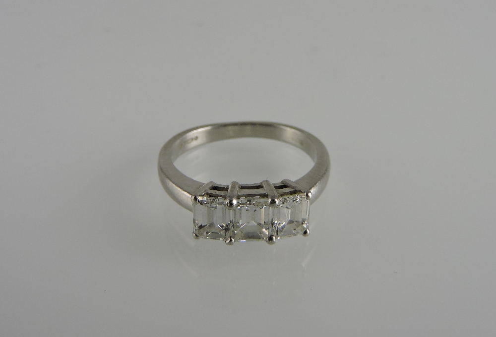 An emerald cut three-stone diamond ring, claw set in a platinum band, weight, 1.23ct.