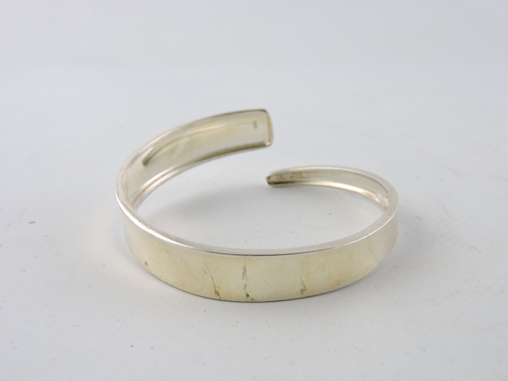 An engraved silver hinged bangle together with two further silver bangles. - Image 2 of 4