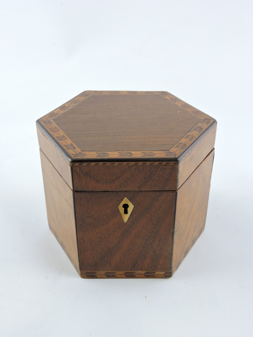 A George III mahogany and maple hexagonal tea caddy with feather and chequer banded inlay. Dia;