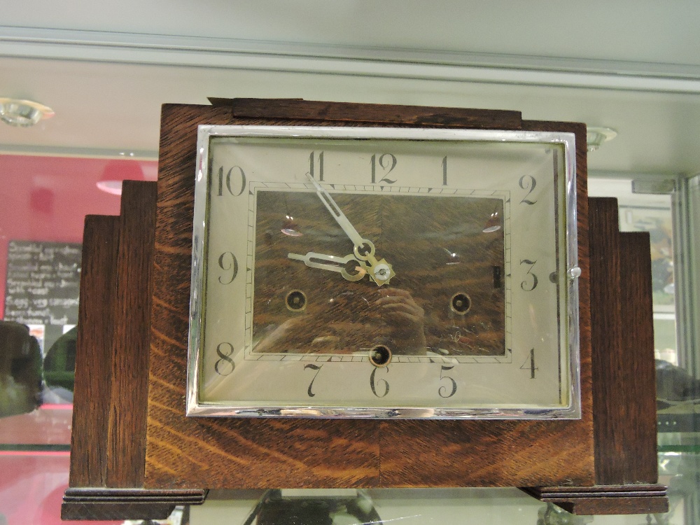 An Art Decco oak eight day mantel clock with silvered chapter ring.
