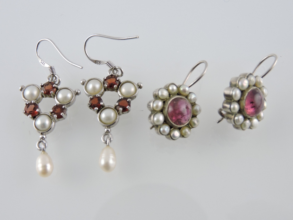 Two pairs of silver seed pearl and garnet set earrings.