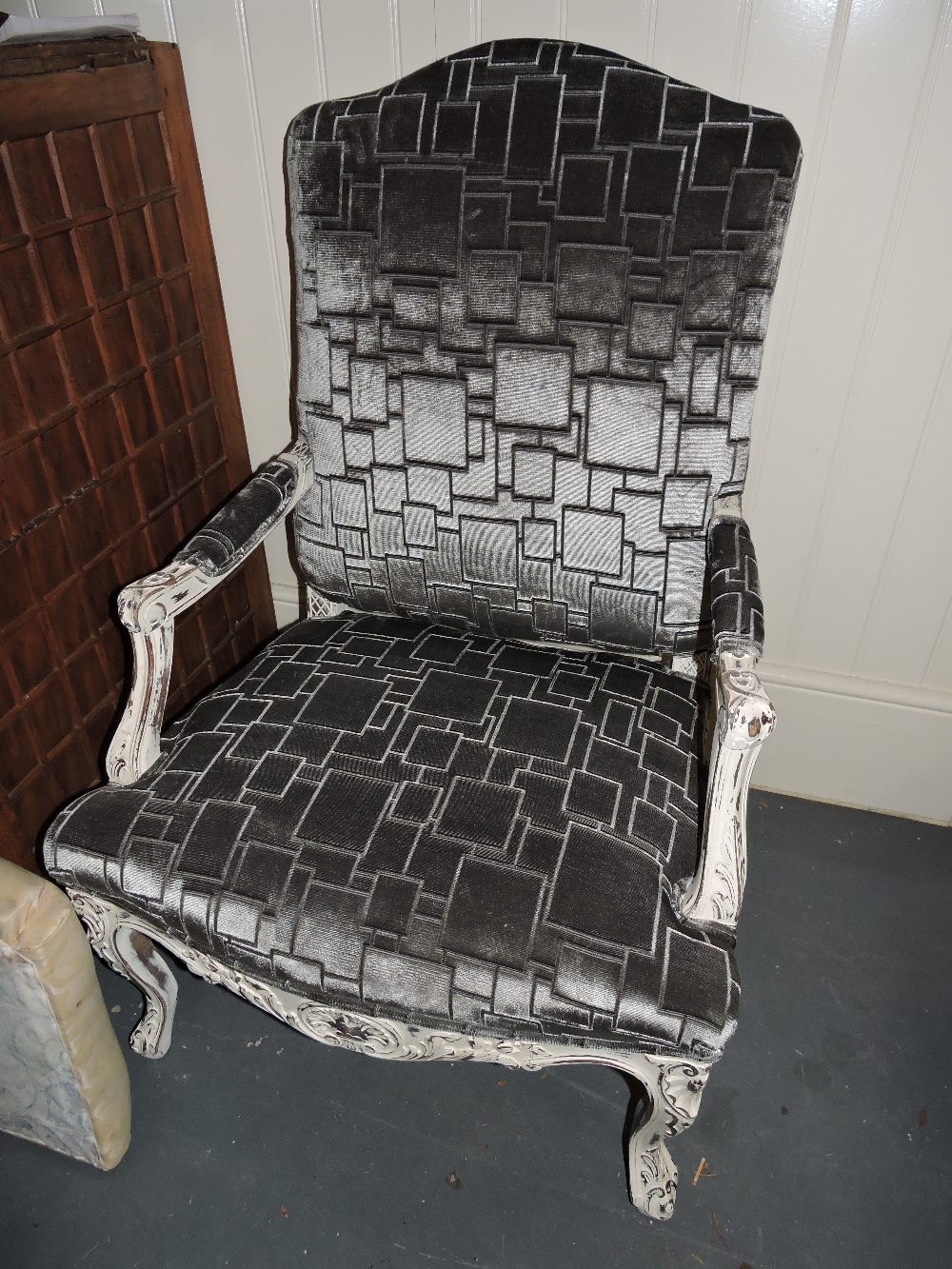 A pair of Louis XVI design white painted open armchairs upholstered in silver geometric fabric on