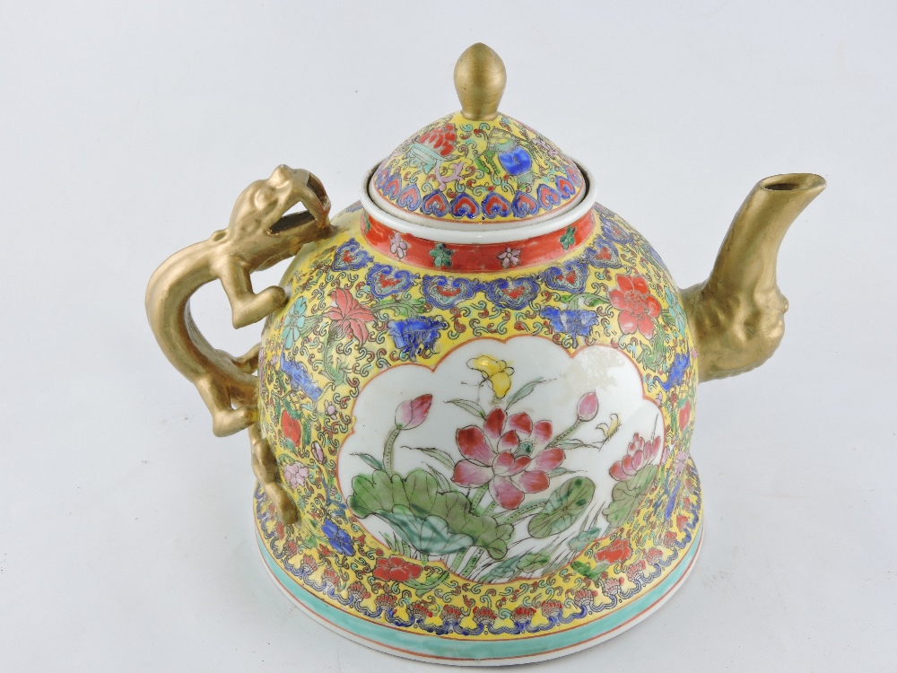 A large Chinese famille jaune teapot with gilt kylin handle, painted with panels of flowering peony,