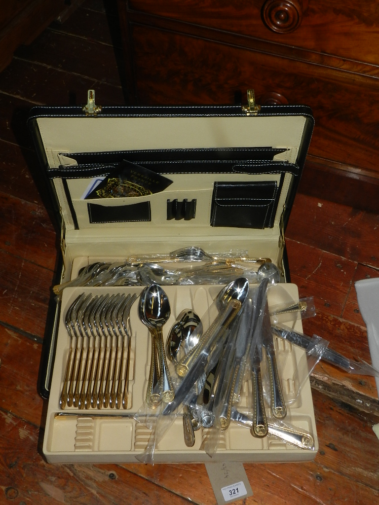 A parcel gilded stainless steel canteen of cutlery contained in a stitched leatherette briefcase.