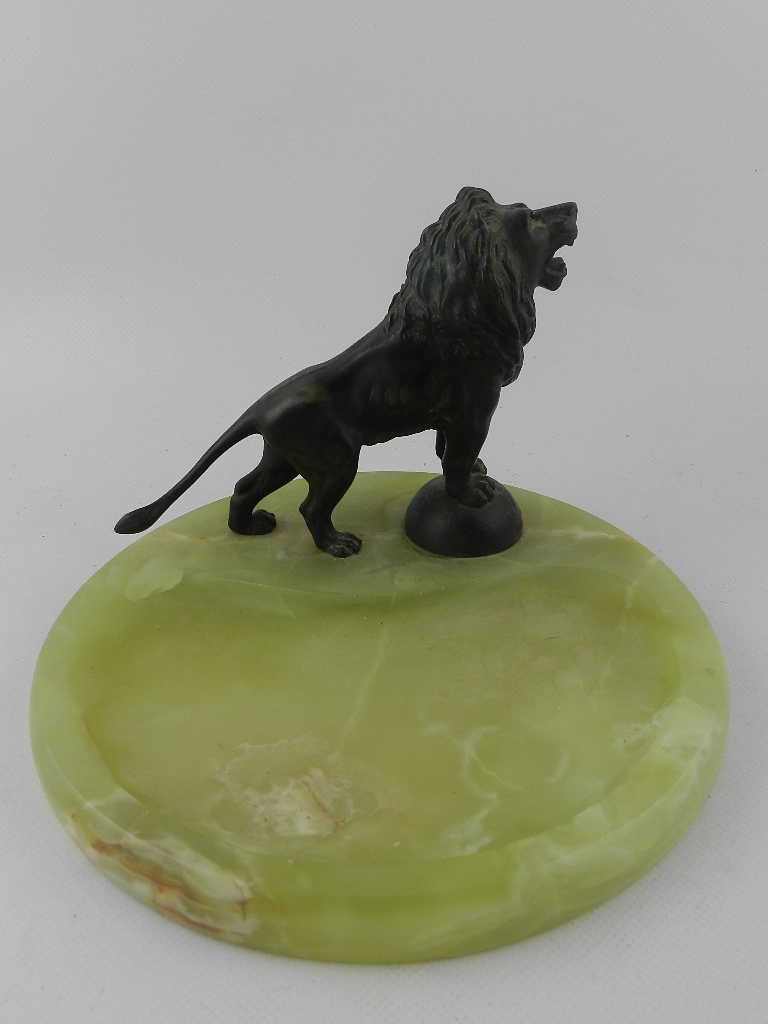 A 1920's French onyx and bronze desk stand surmounted by a Medici lion on a circular plinth base. H: