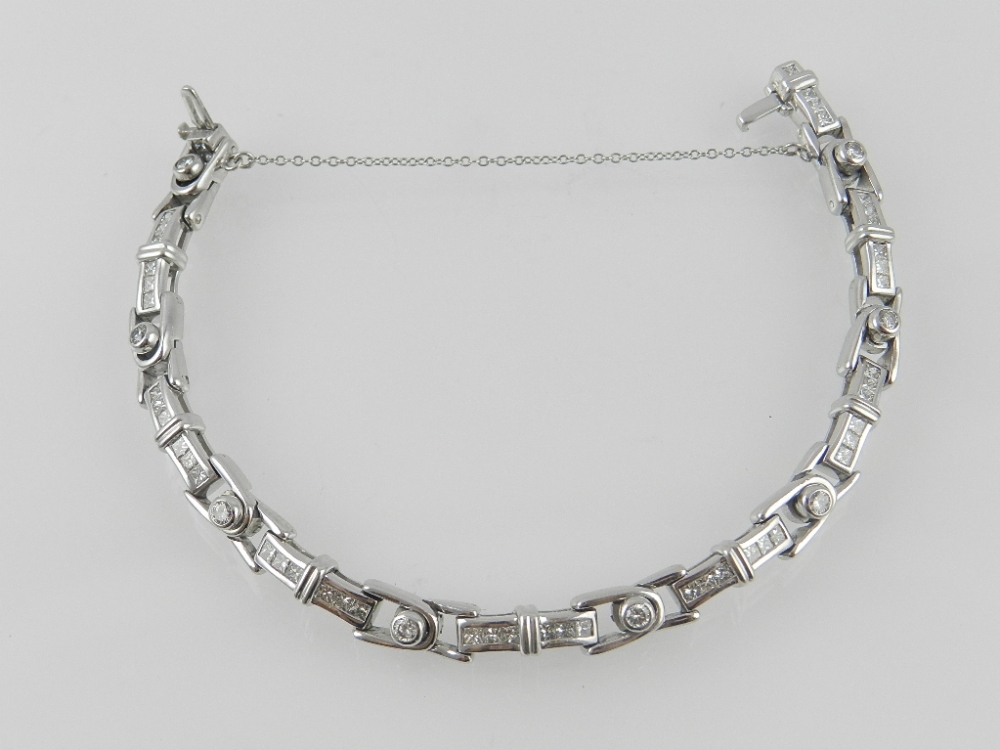 A white metal and diamond bracelet, with alternating links of collet and channel-set diamonds, of