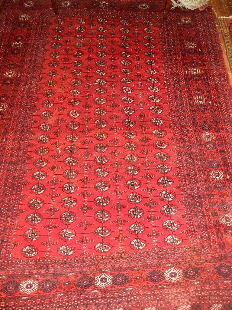 An Afghan Belouch rug, gold medallion decorated on a madder ground, running frieze and panelled