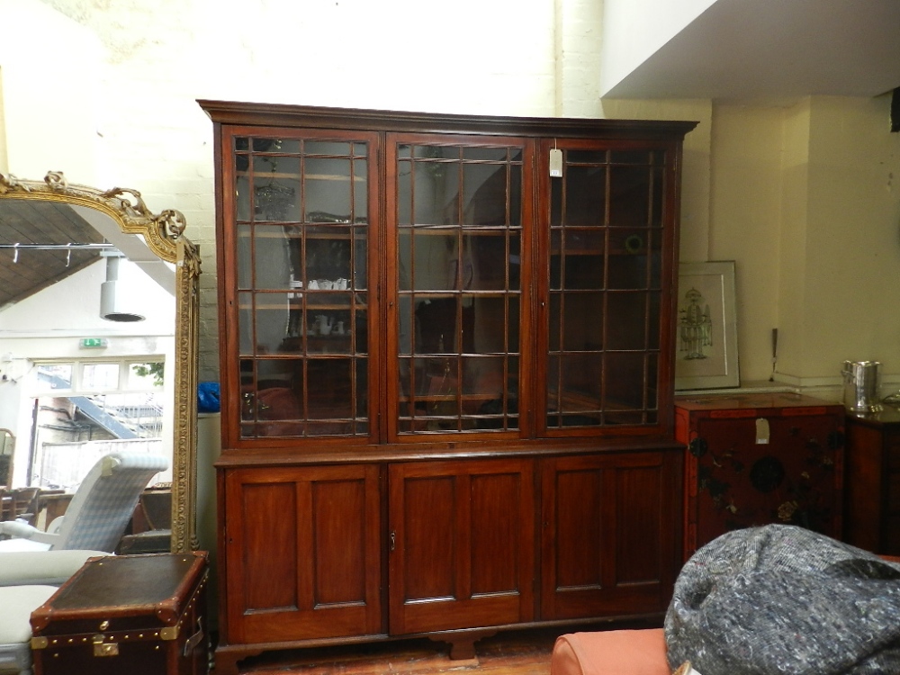 A late Victorian, red stained walnut library bookcase having moulded cornice above three bar
