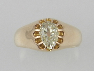 A yellow metal solitaire diamond ring, centred with a pear cut diamond.