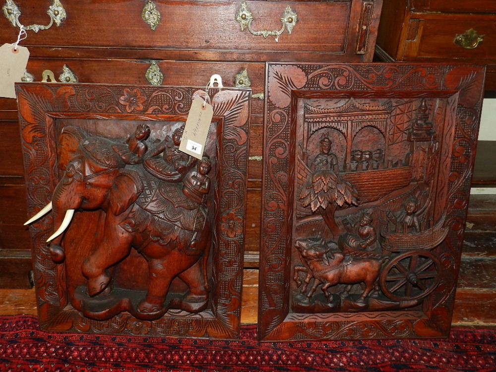 An Thai hard wood wall plaque, relief carved with riders on the back of an elephant set in a