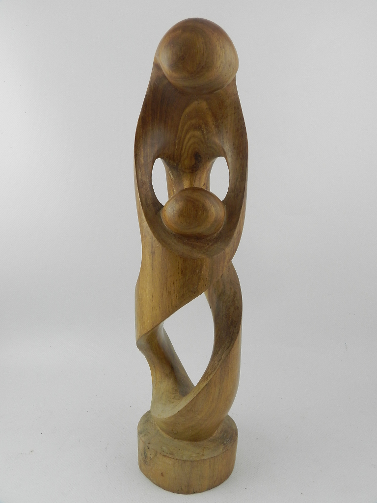 A contemporary hard wood sculpture of a mother and child raised on a socle base. H.39cm
