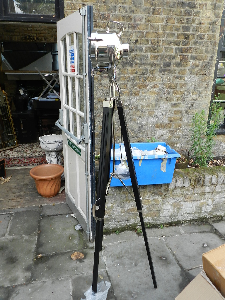 A nickel plated spot lamp raised an adjustable ebonised tripod base.