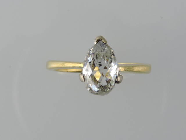 A teardrop reclette cut diamond solitaire, in an 18ct yellow gold band, 2.8g.