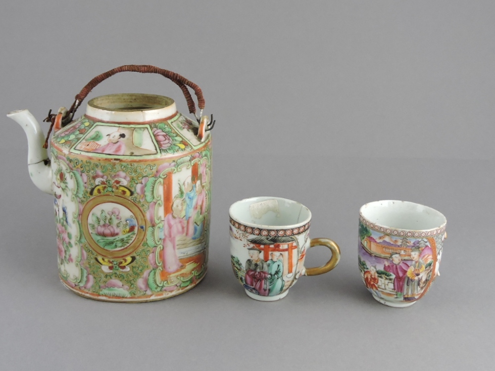 A pair of 19th century famille rose teacups, enamelled decorated with figures in a landscape;