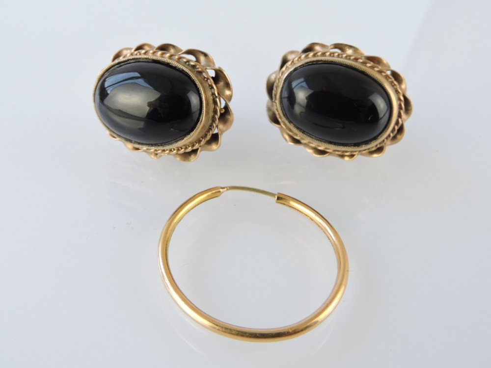 A pair of early 20th century earrings, set with a black cabouchon style stone, within a rope-twist