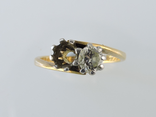 A diamond cross-over ring, with one vacant setting, the remaining diamond approx. 0.33ct, claw set