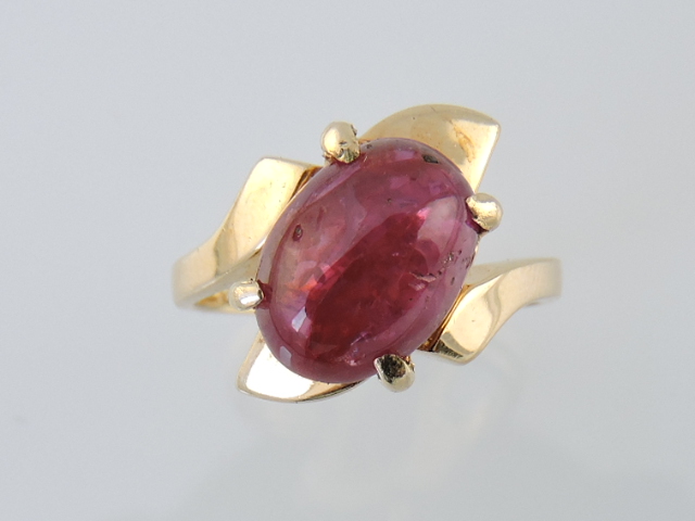 A cabouchon-cut ruby ring, claw set in a 14ct yellow gold band, ruby 3.3cts, 4g.