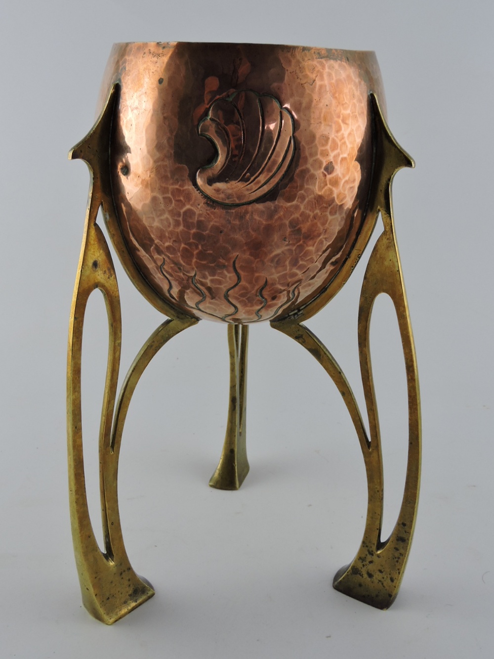 A WMF secessionist copper and brass bowl, the hammered body embossed shell and seaweed motif on