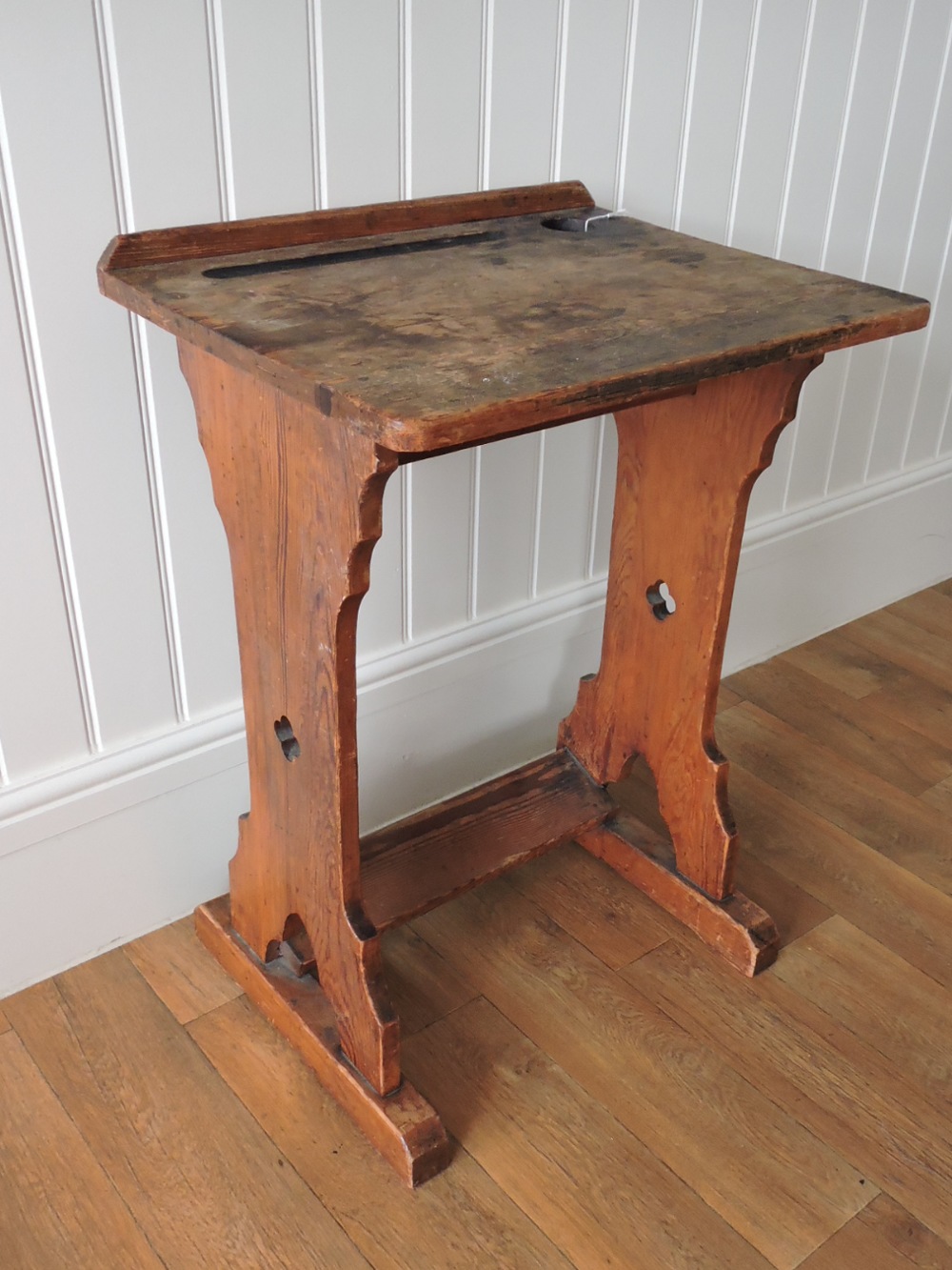 An Arts and Crafts pitch pine school desk rectangular writing surface with ink well and pen tray