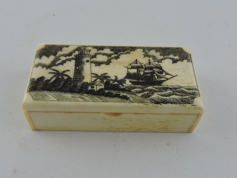 A rectangular scrimshaw style bone snuffbox, decorated with a lighthouse and a three-masted ship