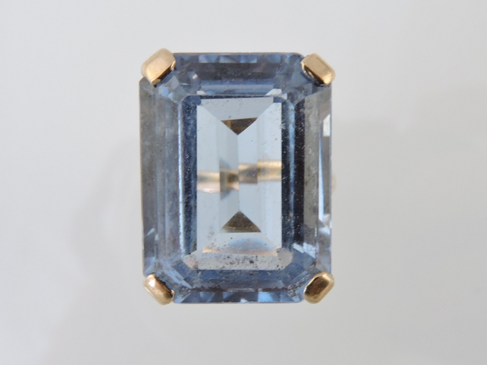 A large blue gemstone ring, possibly topaz, emerald cut in a 9ct gold claw setting, 9.5g.