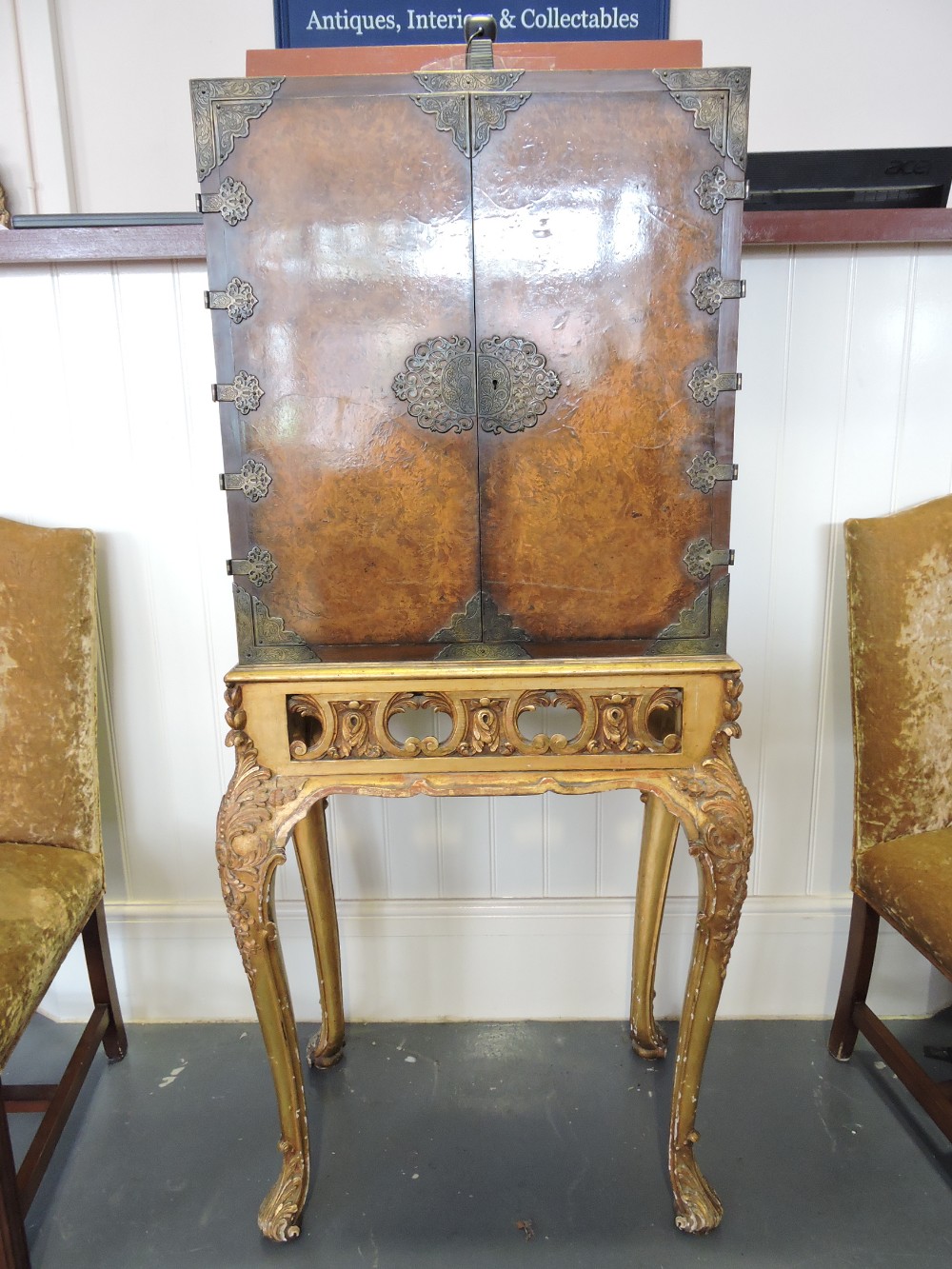 A George III design burr walnut and giltwood cabinet on stand with brass mounted two door upper