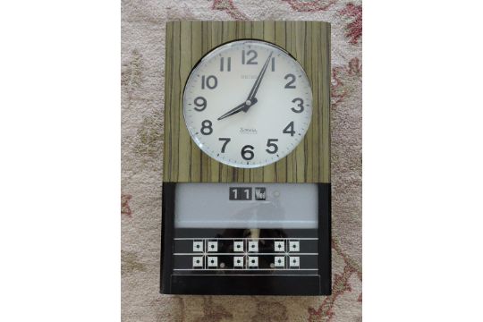 A 1960s Seiko Sonola electric wall clock, with day/date, in faux ebonised  coromandal case, H. 42c