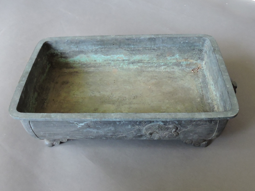 An early 20th century Japanese bronze rectangular jardinière, decorated with vignettes of birds,