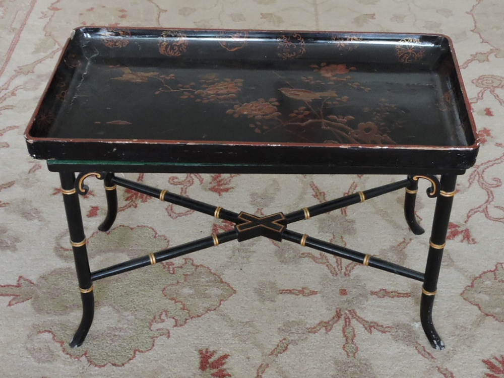 An early 20th Century Chinese black and scarlet lacquer tray top low occasional table decorated with