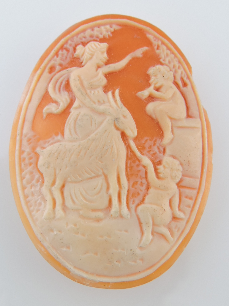 An early 20th century natural shell cameo, a classical lady with a goat and cherubs, H. 4.5cm.