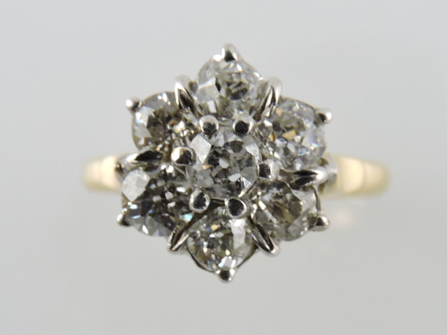 A seven-stone diamond cluster ring, in an 18ct gold band, 1ct.