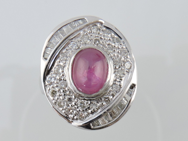 A star ruby and diamond plaque ring, the central stone approx. 3cts, within a table of set with