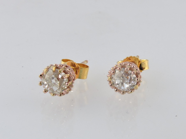 A pair of old-cut diamond ear studs, in antiqued pink gold settings.