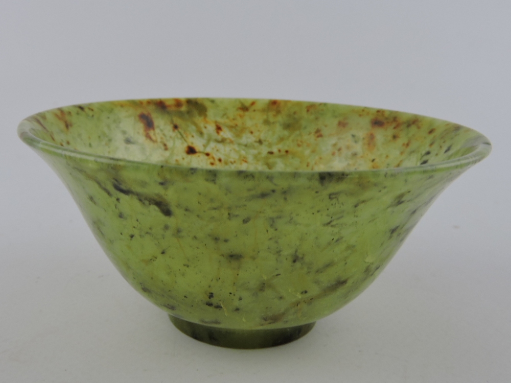 A Chinese mottled jade bowl of flared circular form, Dia.10cm.