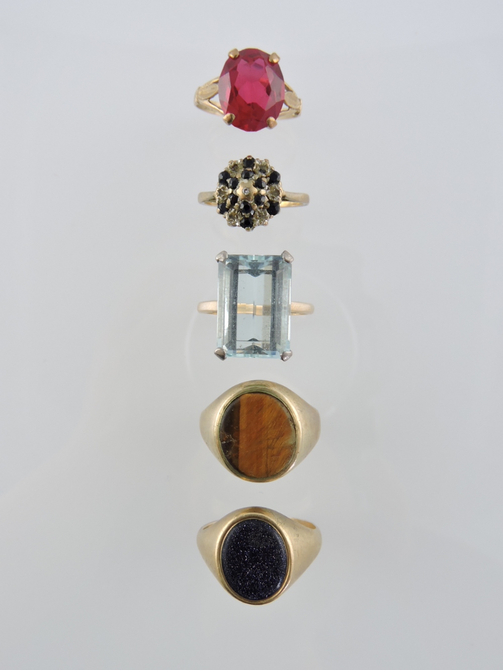 A 9ct tiger's eye ring, a 9ct aquamarine dress ring and three further 9ct rings.