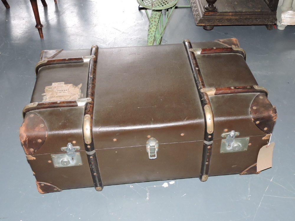 An early 20th Century travelling trunk, brown cloth with wooden binding and leather corners and