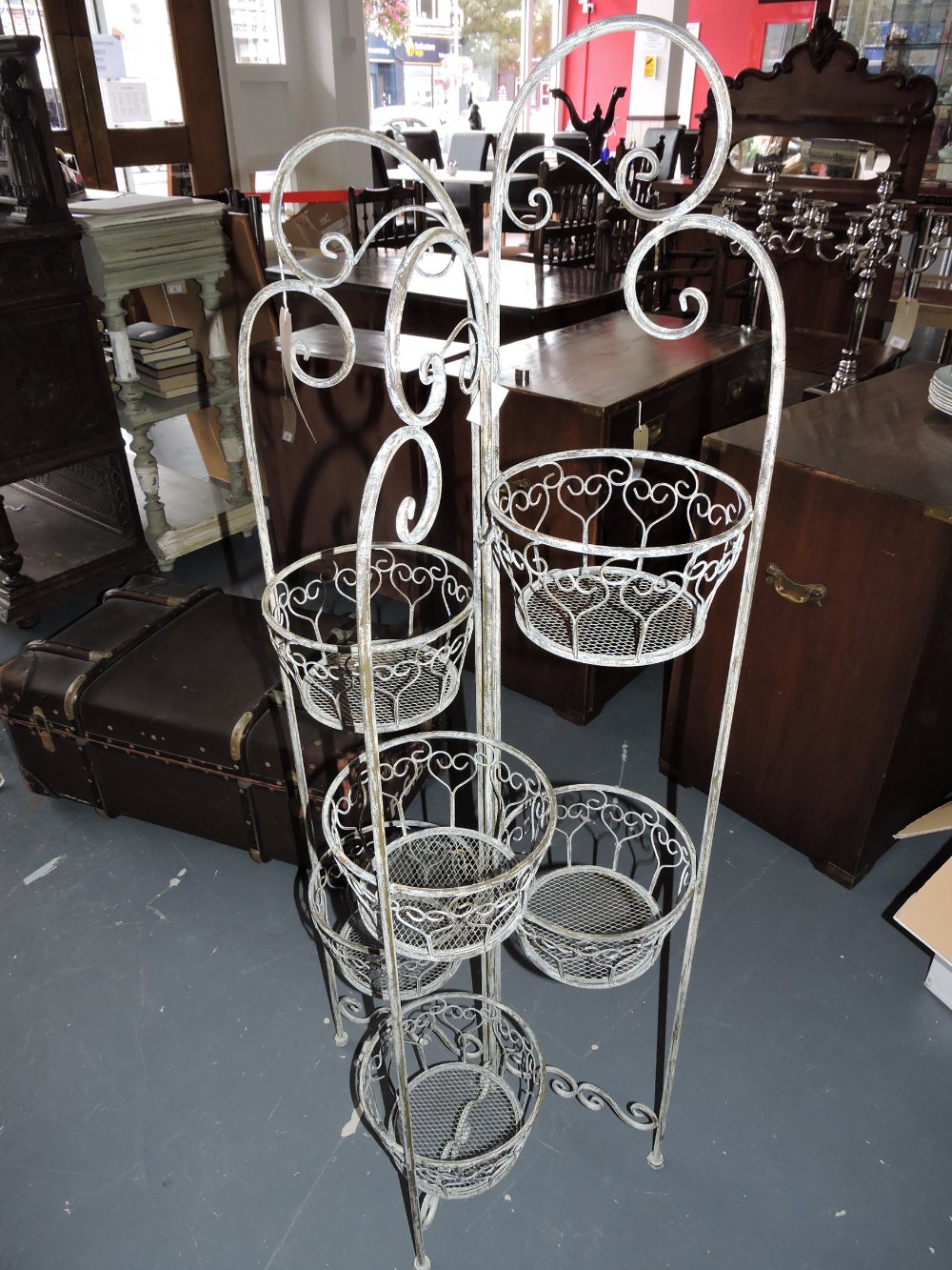 A Victorian style painted metal 6 basket plant holder with folding scrollwork frame H 130 cm