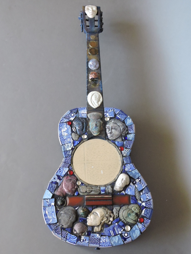 A 20th century classical guitar converted into a mirror, with bevelled circular plate obscuring