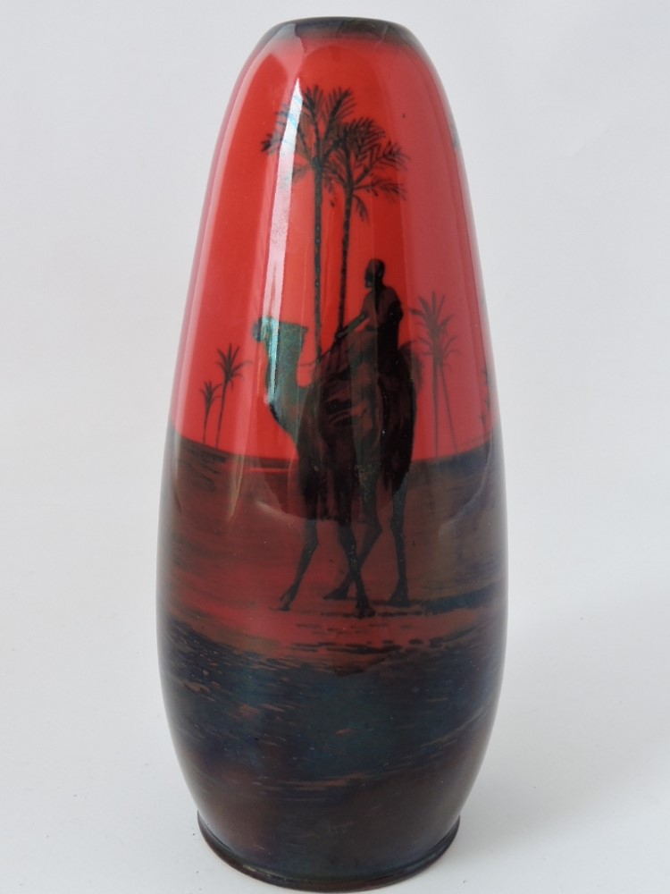 A Royal Doulton flambe vase, decorated with camels and Arabs at an oasis, H. 18cm