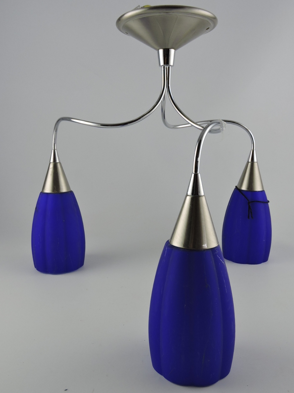 A modern chrome and blue glass three branch ceiling light.