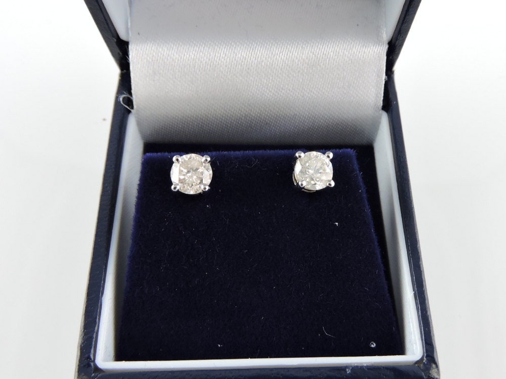 A pair of diamond solitaire ear studs, in 18ct white gold claw mounts, total weight 1.3cts.