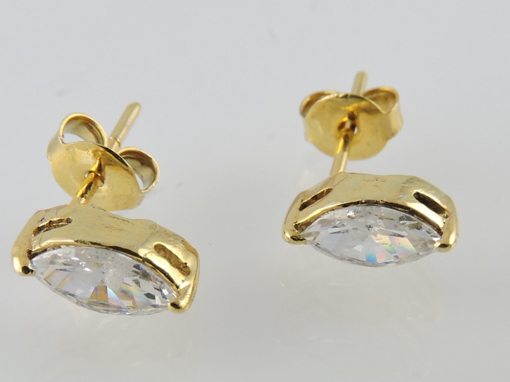 A pair of cubic zirconia marquise-cut ear studs, in yellow metal setting, 1.5g.