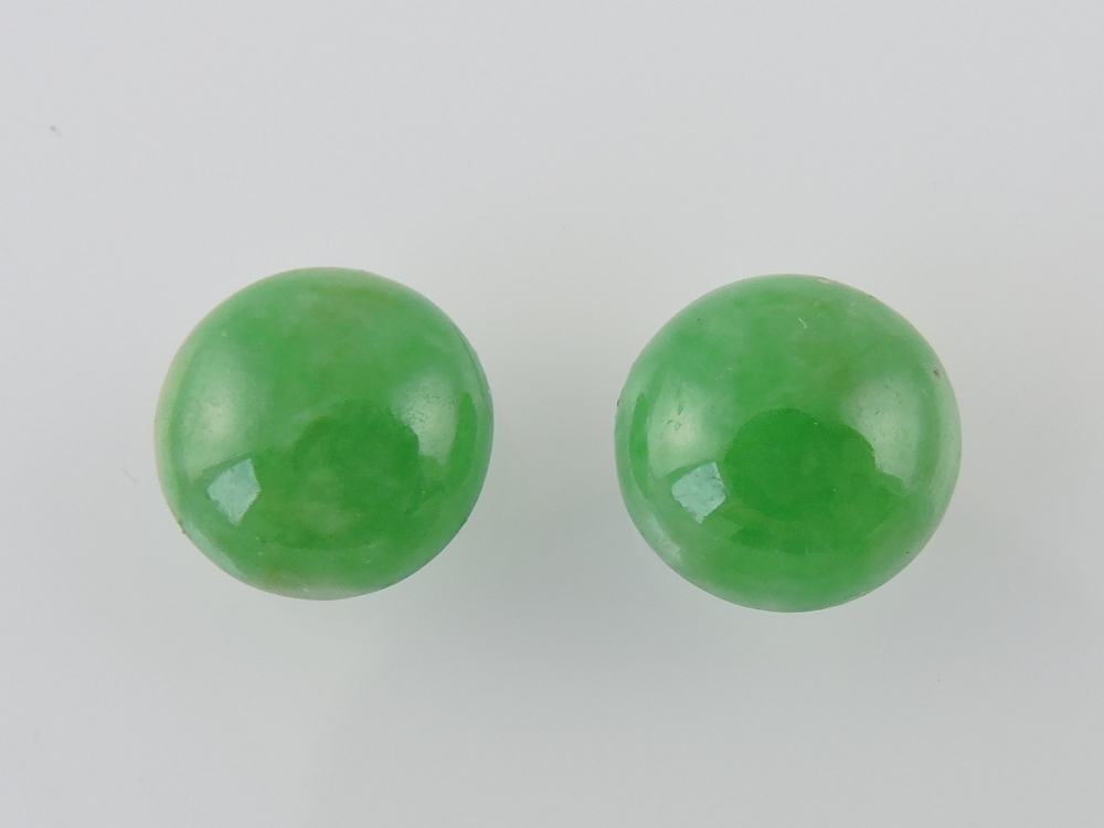 A pair of circular cabochon cut jade stones, 3.3g.