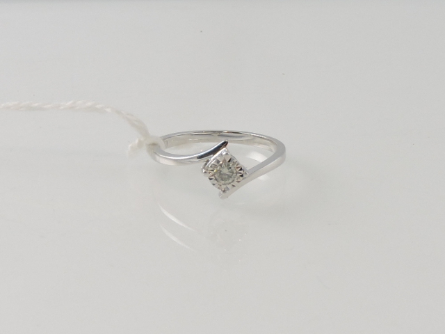 A diamond solitaire ring, with a square setting on a white metal band, 2g.