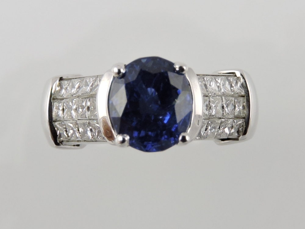 A sapphire and diamond dress ring, the oval claw-set sapphire with diamond shanks on a white gold