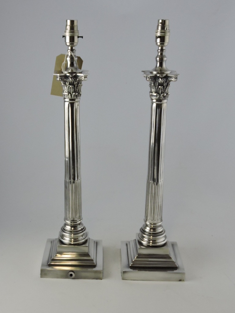 A pair of white metal table lamp bases, in the form of Corinthian columns with square stepped bases,