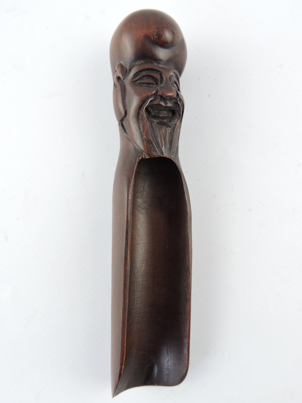 A Japanese hardwood tea caddy scoop, with carved mask handle, L. 13cm.