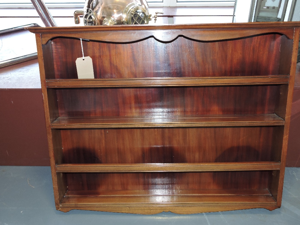 A mahogany hanging plate rack, with shaped cornice and apron and two shelves with bars, W. 97cm.